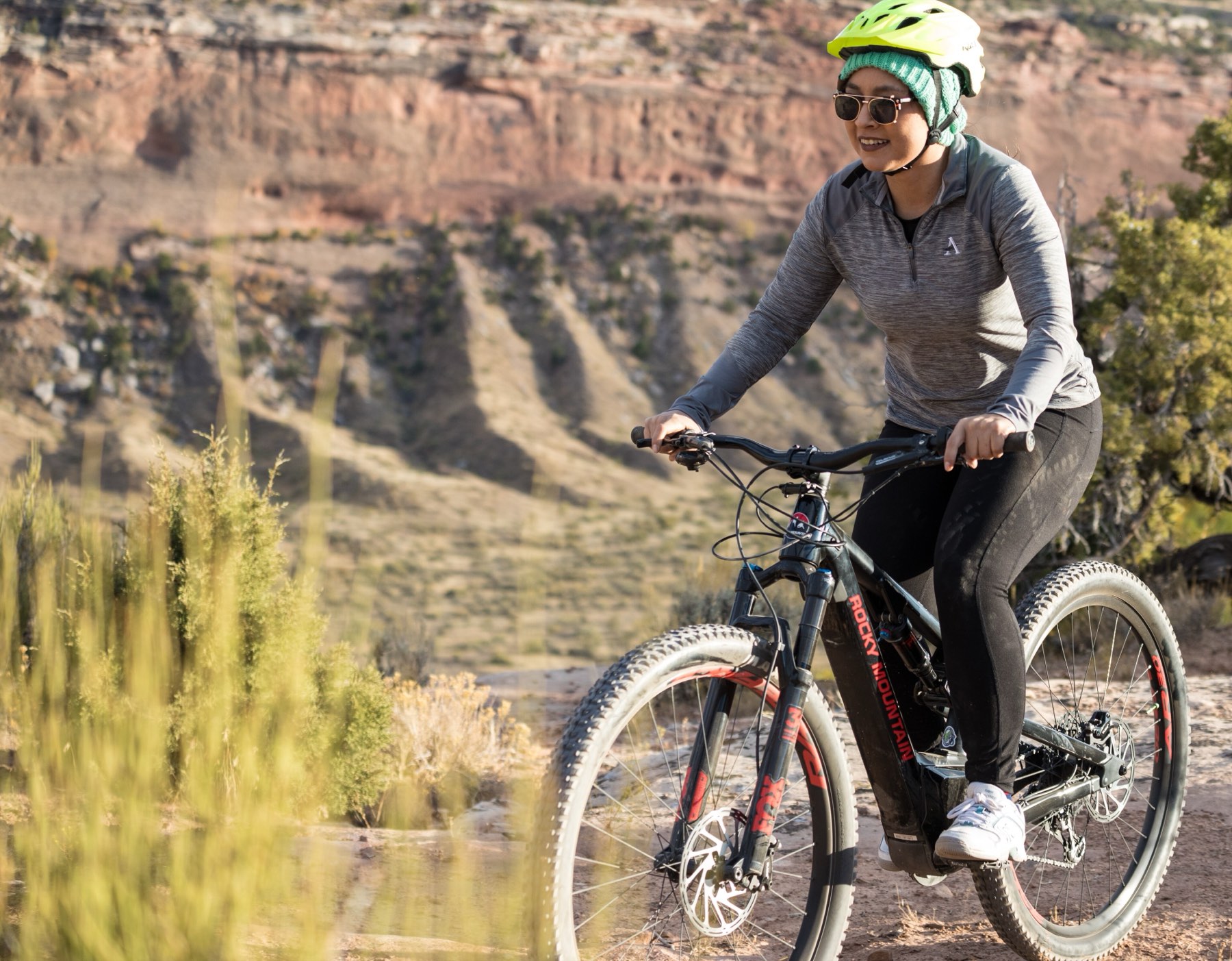 A rider in a red jacket on an electric mountain bike on a dry trail