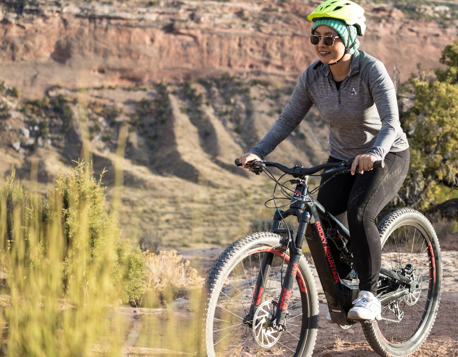 A rider in a red jacket on an electric mountain bike on a dry trail